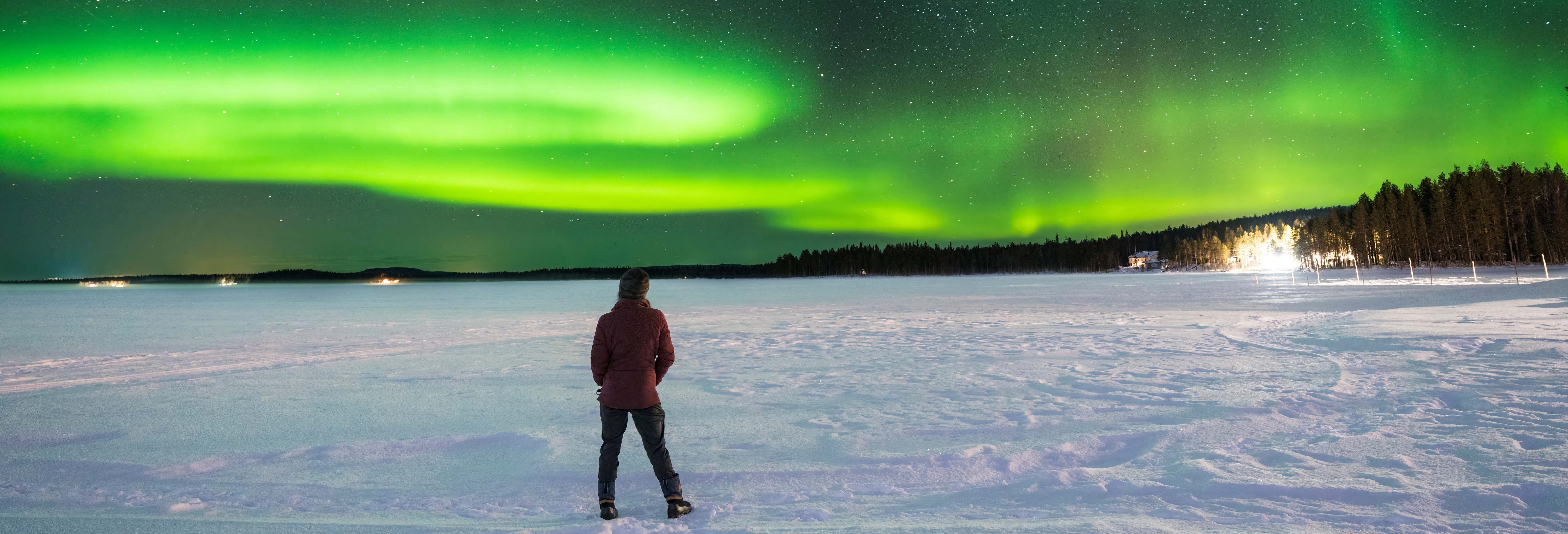 Paseo en moto de nieve bajo la aurora boreal