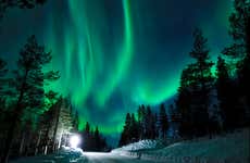 Paseo en trineo de perros husky bajo la aurora boreal