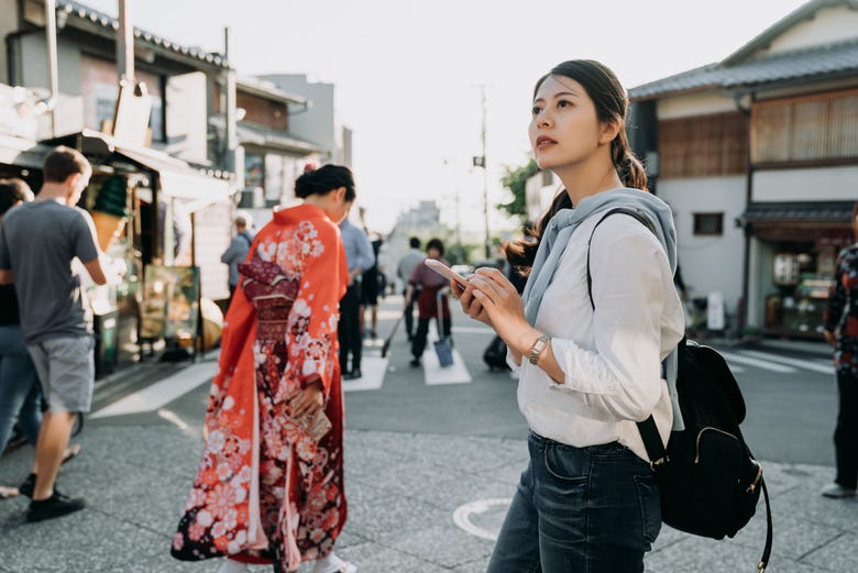Mujer mirando su móvil en Kioto
