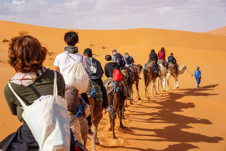 Grupo andando de camelo pelo deserto de Merzouga