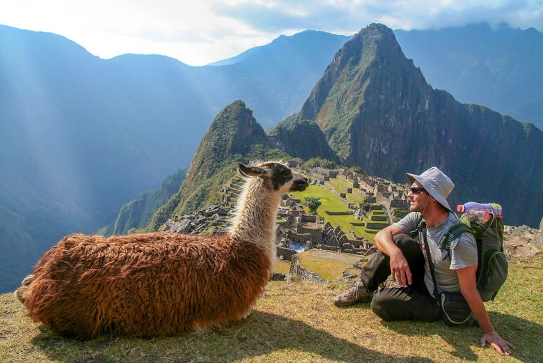 Visitante com uma lhama em Machu Picchu