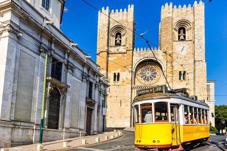 Um bonde passando diante da catedral de Lisboa