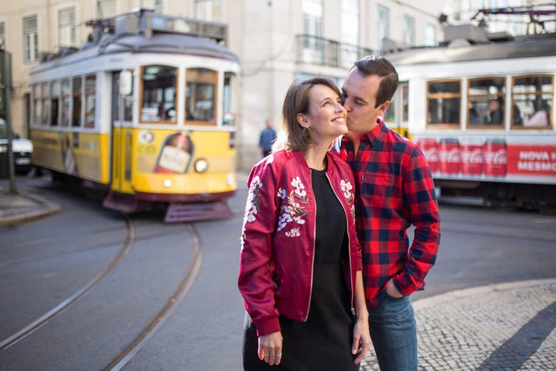 Couple posing next to the famous trams in Lisbon